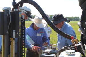 Producers examine central alberta forage and livestock association's wintex soil sampler while in the field on a field tour in august
