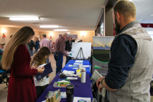 producers and locals gather around a trade booth at the Clearwater County Cattlemen's Day event in Leslieville.